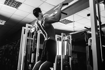 Strong Bodybuilder Doing Exercise For Back in Gym