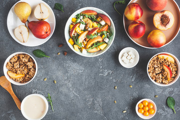 Breakfast with muesli, peach salad, fresh fruit, yogurt on dark background. Healthy food concept. Flat lay, top view
