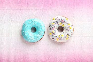 Tasty donuts with sprinkles on paper background