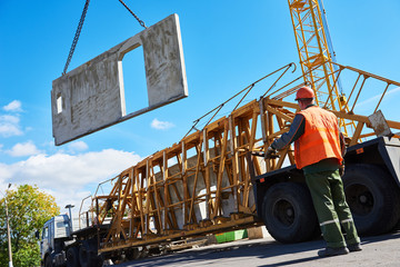 Construction industrial worker operating hoisting process of concrete slab