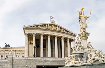 Fototapeta na wymiar main entrance of Austrian parliament building in Greek style with statues of philosophers and white columns with famous Pallas Athena fountain and in Vienna