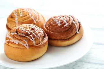 Cinnamon buns in plate on wooden table