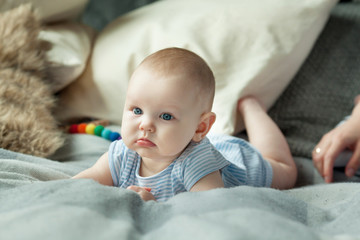 White little baby girl in a lying pose in the interior