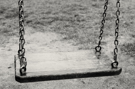 Empty swings. The Lost Child. Black and white image.