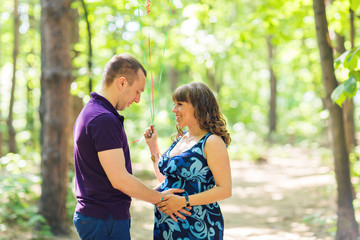 Portrait of a caucasian pregnant woman and her husband outdoors