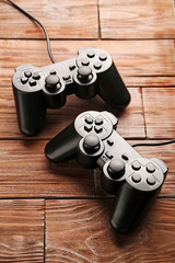 Black joysticks on a brown wooden table © 5second