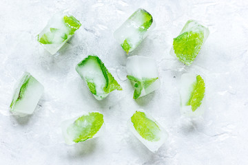 mint in ice cubes stone background top view