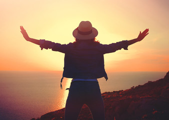Fototapeta premium Young stylish carefree woman enjoying sunset at sea
