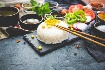Boiled Dish Rice with vegetables and spices over dark rustic background. Vegetarian food concept.  Top view. Copy space