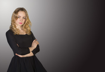 Young blonde woman in black dress, isolated black on white background