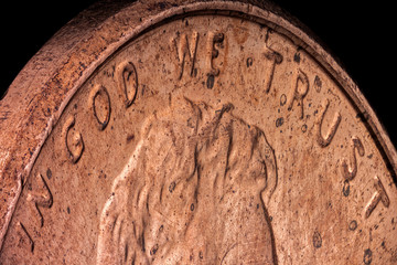 Extreme macro, sharp and detailed, of an American copper penny, emphasizing the official motto of the United States: In God We Trust
