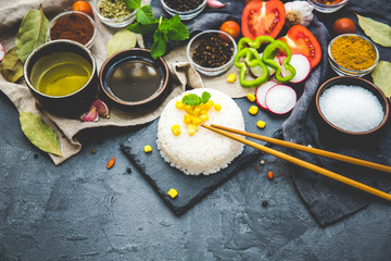 Boiled Dish Rice with vegetables and spices over dark rustic background. Vegetarian food concept.  Top view. Copy space