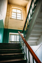 Obraz premium Inside empty old house with high ceilings, staircase, steps, window