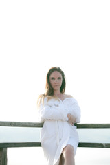 Obraz premium The girl is standing in the bathrobe in the sun