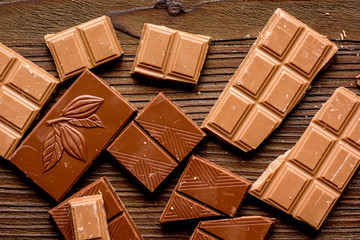 chopped chocolate pieces for dessert wooden desk background top view