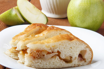 Homemade apple cake and green apple over natural wood background