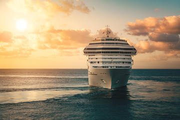 Luxury cruise ship leaving port at sunset - obrazy, fototapety, plakaty