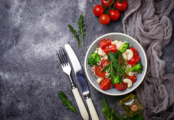 Salad with pasta, tomatoes, broccoli and arugula