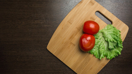heart-shape tomato on wooden cutting board