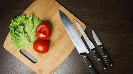 tomato and a kitchen knife on a cutting board