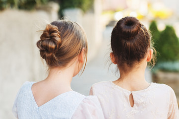 Back view of two little girls with beautiful hairpiece style