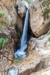 Fototapeta na wymiar Tall waterfall in Quebrada del Colorado canyon near Cafayate, Argentina