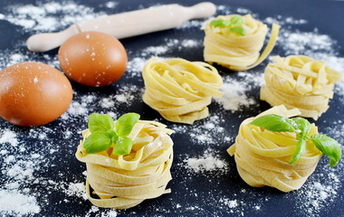 Italian raw homemade pasta tagliatelle. Black background
