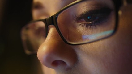 Young business woman in glasses working in the office on the laptop. Close up. The image of computer screen displayed in the glasess. - Powered by Adobe