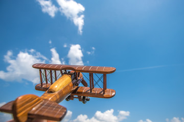 The wooden airplane fly on the cloud background