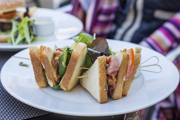 Healthy sandvich with salad served on table. Hamburger on white plate