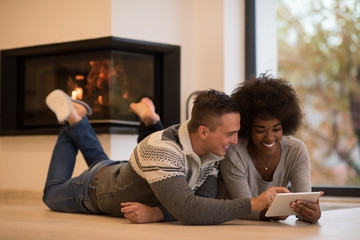 multiethnic couple using tablet computer on the floor