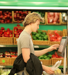 Young man with a shopping cart in a supermarket 