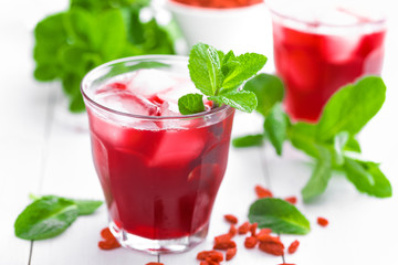 Healthy detox drink with goji berries infused in water with ice, cold refreshing beverage
