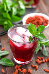 Healthy detox drink with goji berries infused in water with ice, cold refreshing beverage