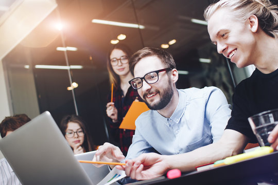 Bearded man talking with colleague about new startup project. Joyful team brainstorming. New marketing plan researching