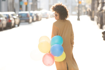 Happy african american girl with balloons.