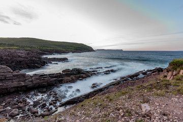 Fototapeta na wymiar Waves crashing on the shores of Newfoundland in the setting sun