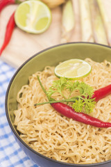 Instant noodles in bowl on wood background