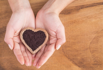 Acai powder in bowl between hands - Euterpe oleracea