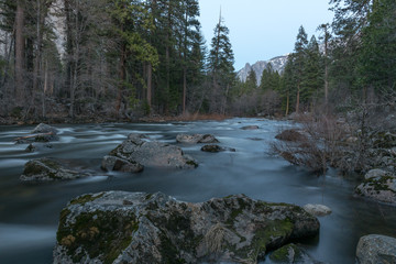 Calm river running through tress and mountains in California