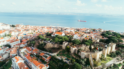 Aerial panoramic view over Lisbon in beautiful sunset sunshine.Saint George castle,downtown and neighbourhood of Alfama,river Tagus in european capital,Lisbon,Portugal.Aerial travel photography
