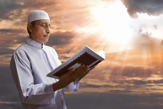 Old muslim man reading koran