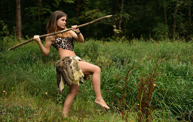 Girl hunter with a spear in the forest
