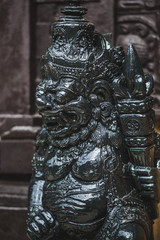 Black statuette of a Hindu deity in Ubud garden in Bali. Symbolism and religion in Indonesia