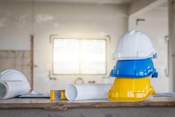 The safety helmet and the blueprint on table at construction site