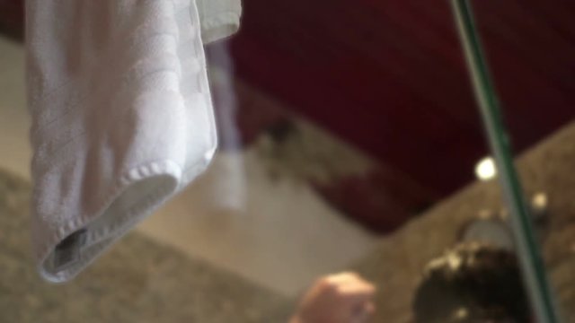 Defocused man in shower dancing oddly in modern bathroom