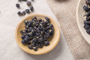 Top view of black wolfberry on the table. Traditional Chinese black herbs dried wolfberry close up.