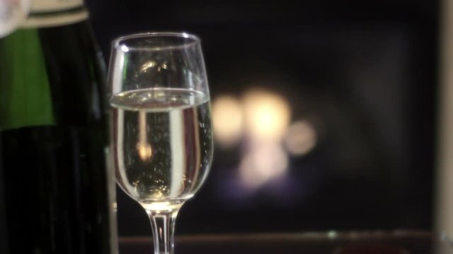 Champagne glass in front of bokeh luxury fireplace in hotel