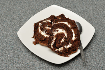 Chocolate swiss roll displayed on a white plate