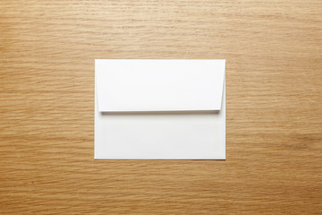 a white envelope on the wood table.
